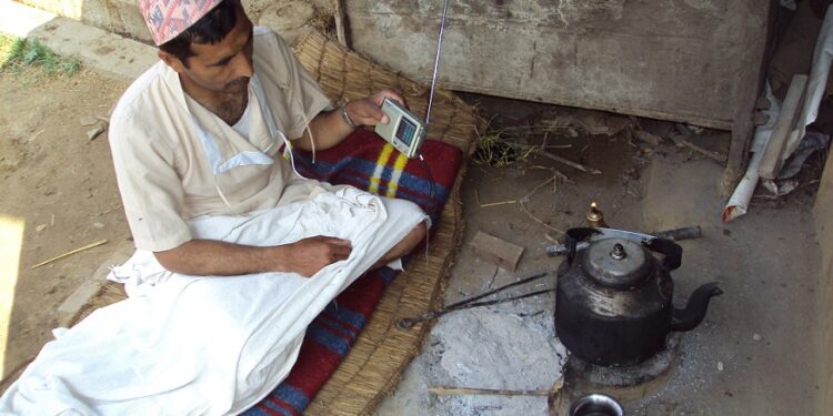 The effect of community specific radio: Krishi FM does wonders for Dhading folks 1 Man listening radio by the side of his outdoor kitchen & bed in a village in rural Nepal; communication is everywhere!